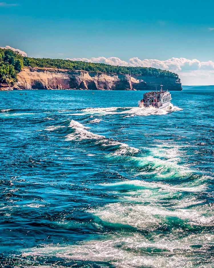 A Pictured Rocks Cruises boat passes large formations along the Pictured Rocks National Lakeshore. Photo courtesy of IG user @glundteigen.
