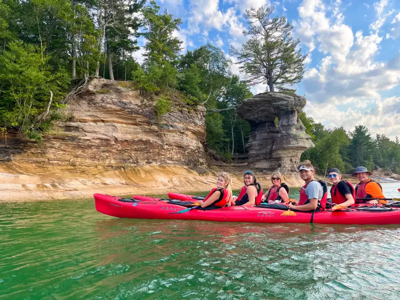 A Pictured Rocks Kayaking tour poses in front of Chapel Rock.